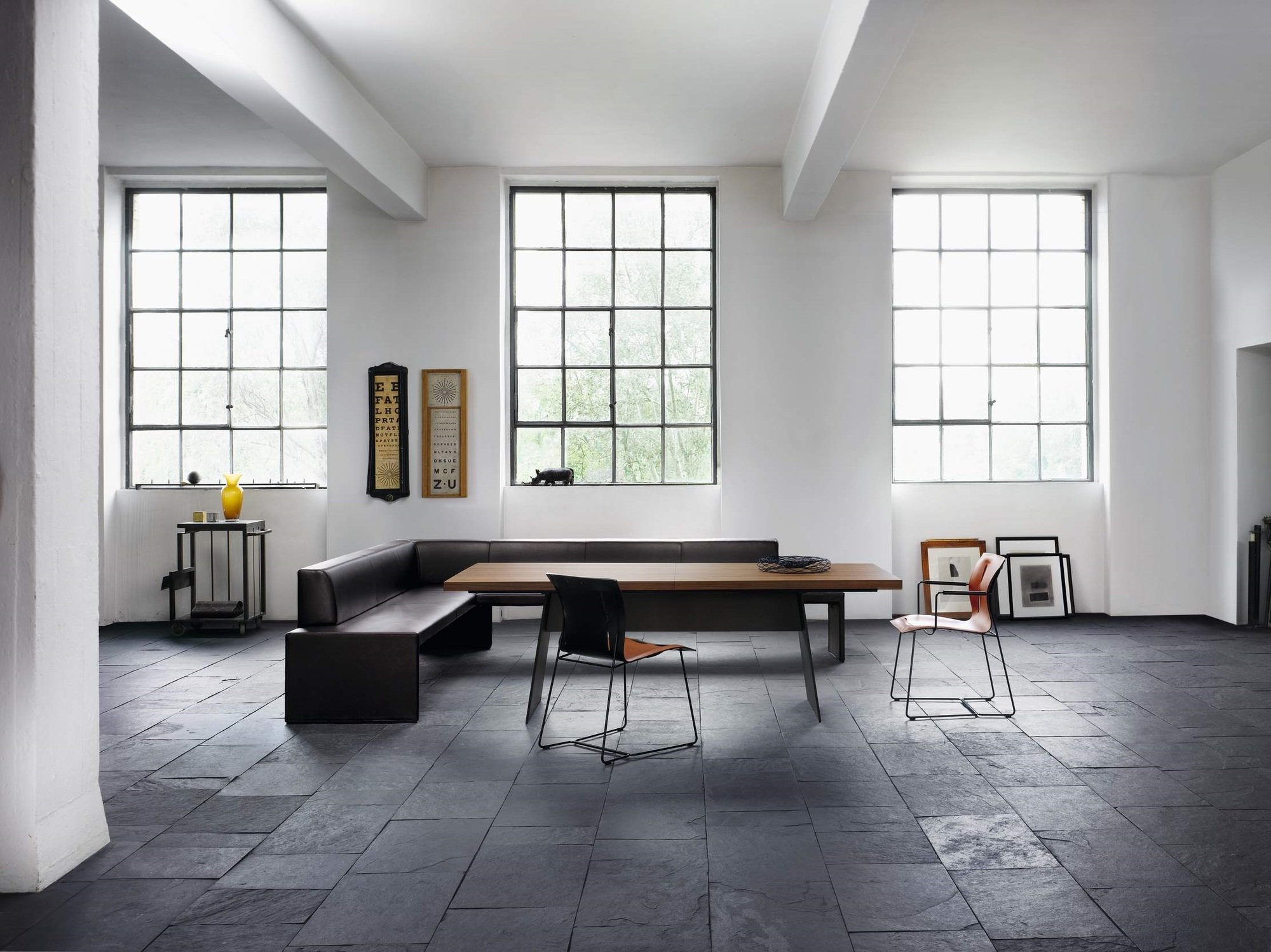 Heller Raum mit Tadeo Table Tisch von Walter Knoll, Lederbank und Stühlen.