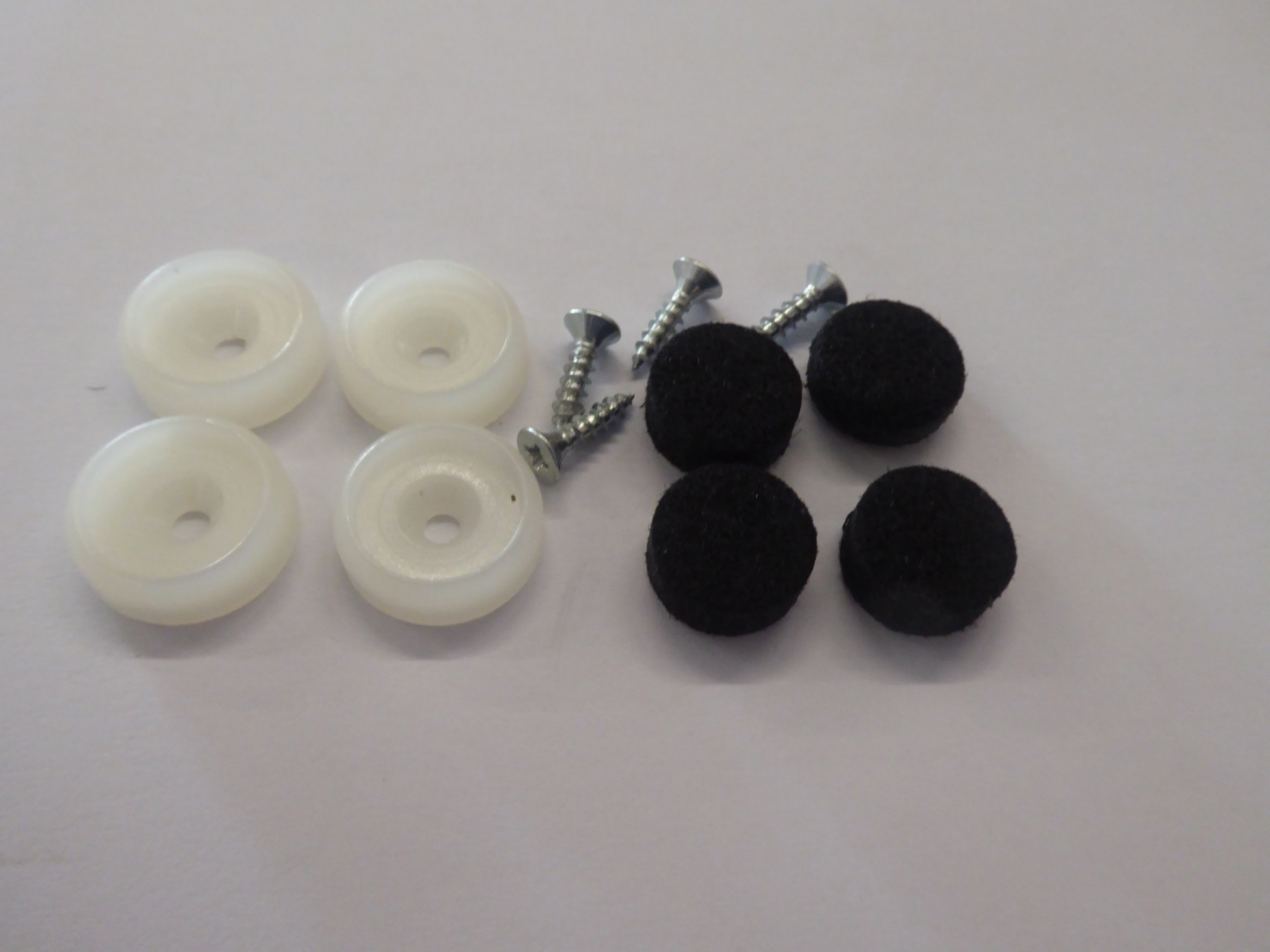 Filzgleiter Set für Eames Chair: Weiße Gleiter, Schrauben und schwarze Filz Pads.