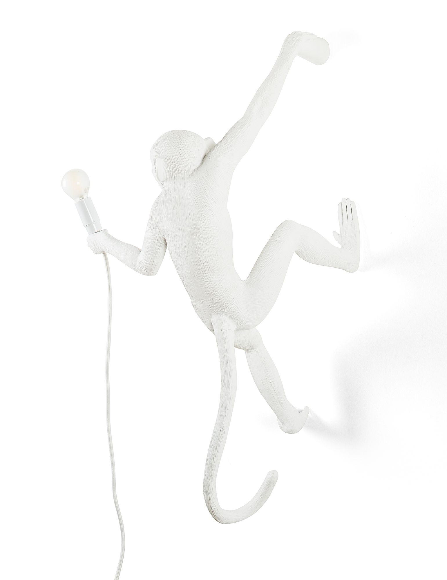 Weiße Monkey Lamp Wandleuchte (rechts) von Seletti mit Lampe in der Hand. Design Lampe.