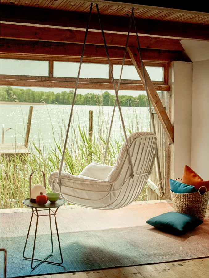 Leyasol Lounge Schwingsessel von Freifrau Manufaktur vor Fenster mit Seeblick. Hängesessel für entspannte Momente.