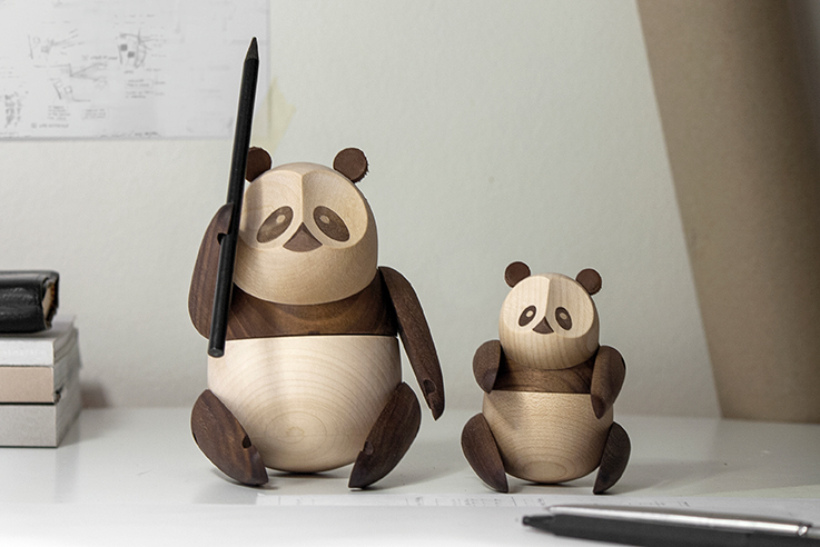 Zwei Panda Holzfiguren von Architectmade, eine hält einen Stift, dekorative Holztiere.