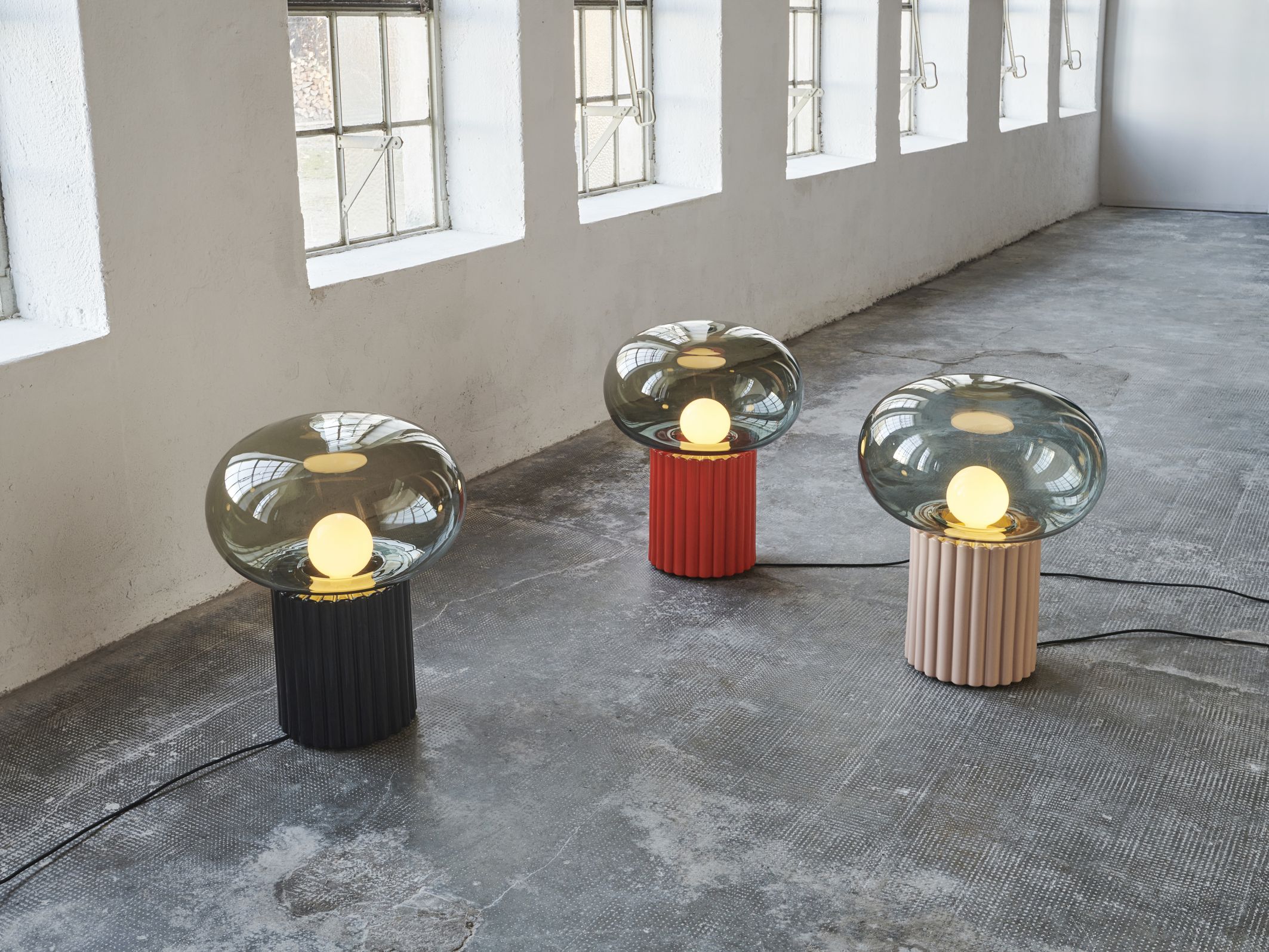 Drei Fungi Bodenleuchten Favius in Schwarz, Rot und Beige mit Glaslampenschirm.