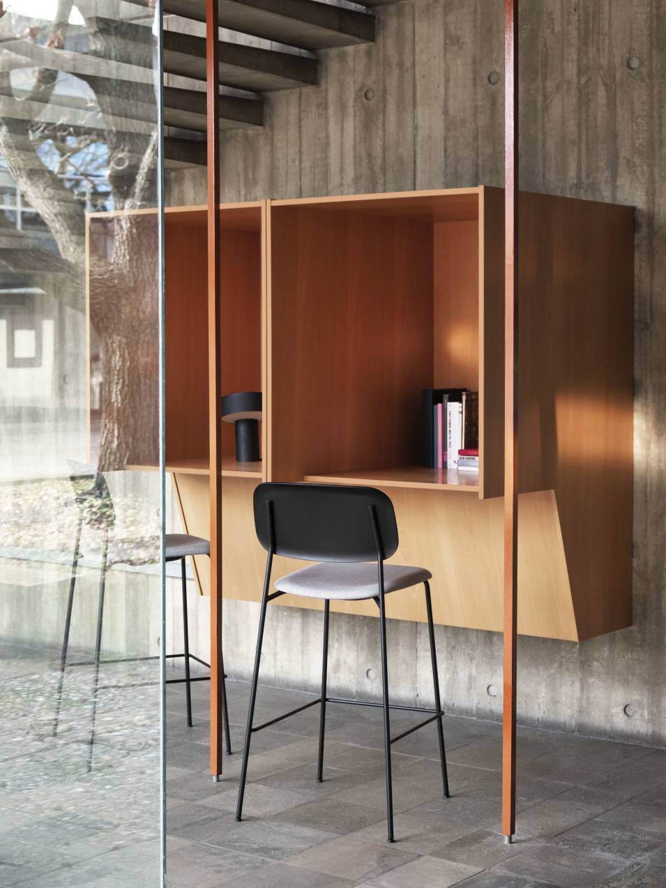 Khaki Slant Tischleuchte von Hay auf einem Schreibtisch mit Regalen und Stühlen.