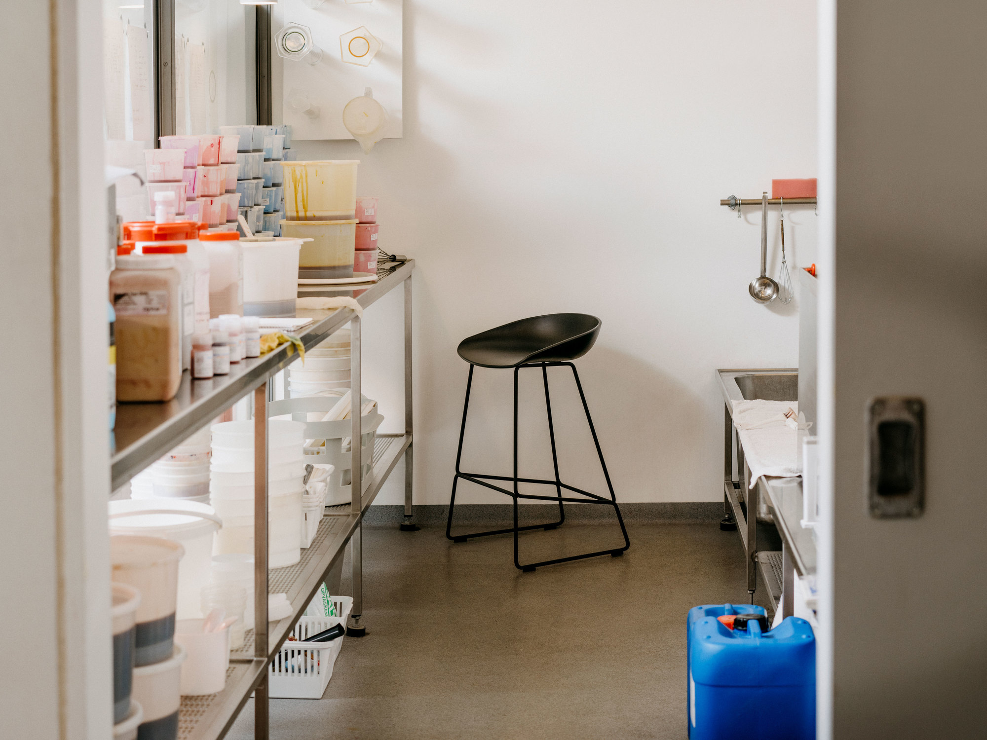 Schwarzer About a Stool AAS 38 Barhocker von Hay in einem hellen Raum mit Regalen.