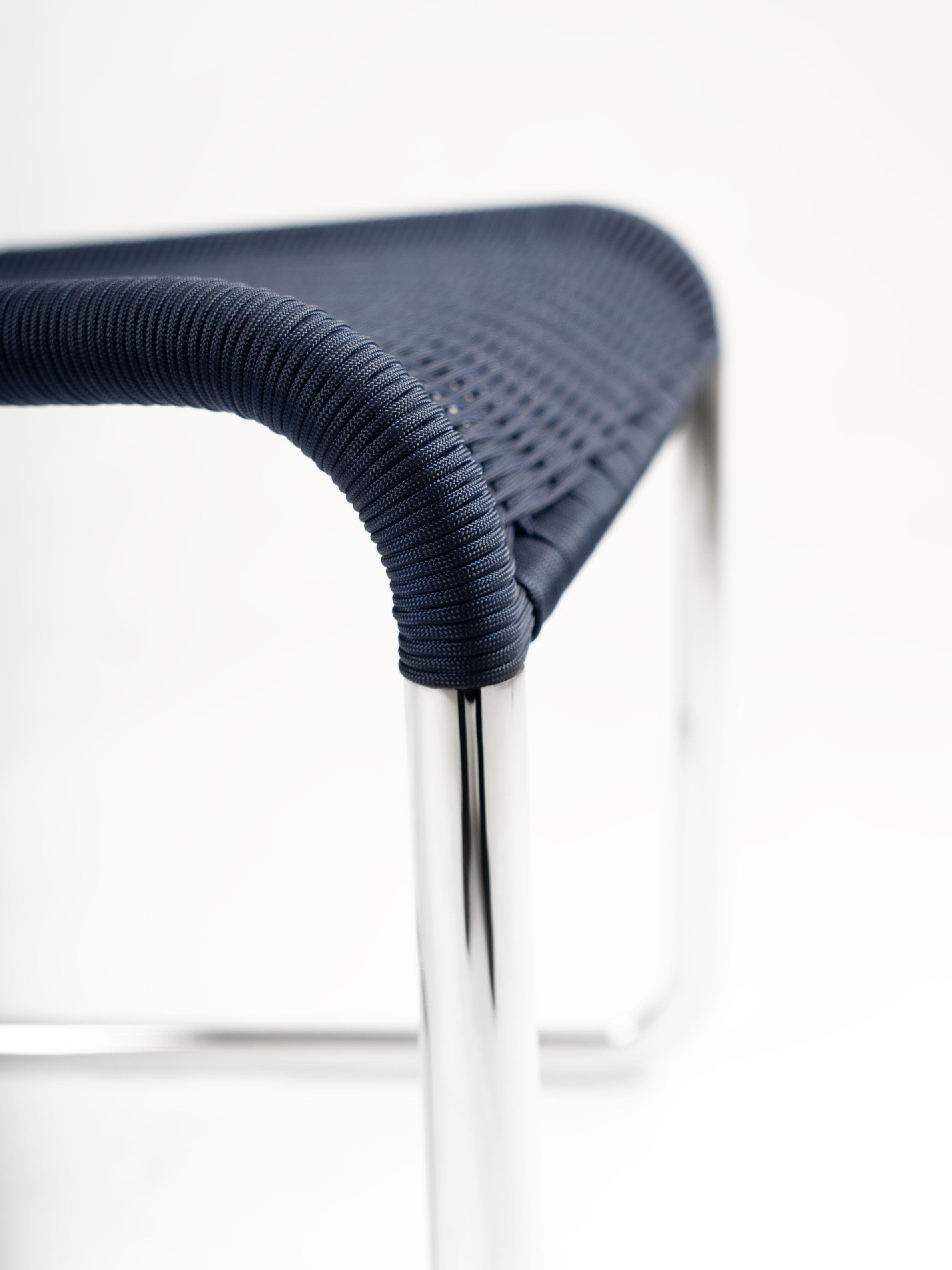 Detailaufnahme des B25 Kragstuhls von Tecta in Dunkelblau mit verchromtem Stahlrohrgestell. Designklassiker für modernes Wohnen.