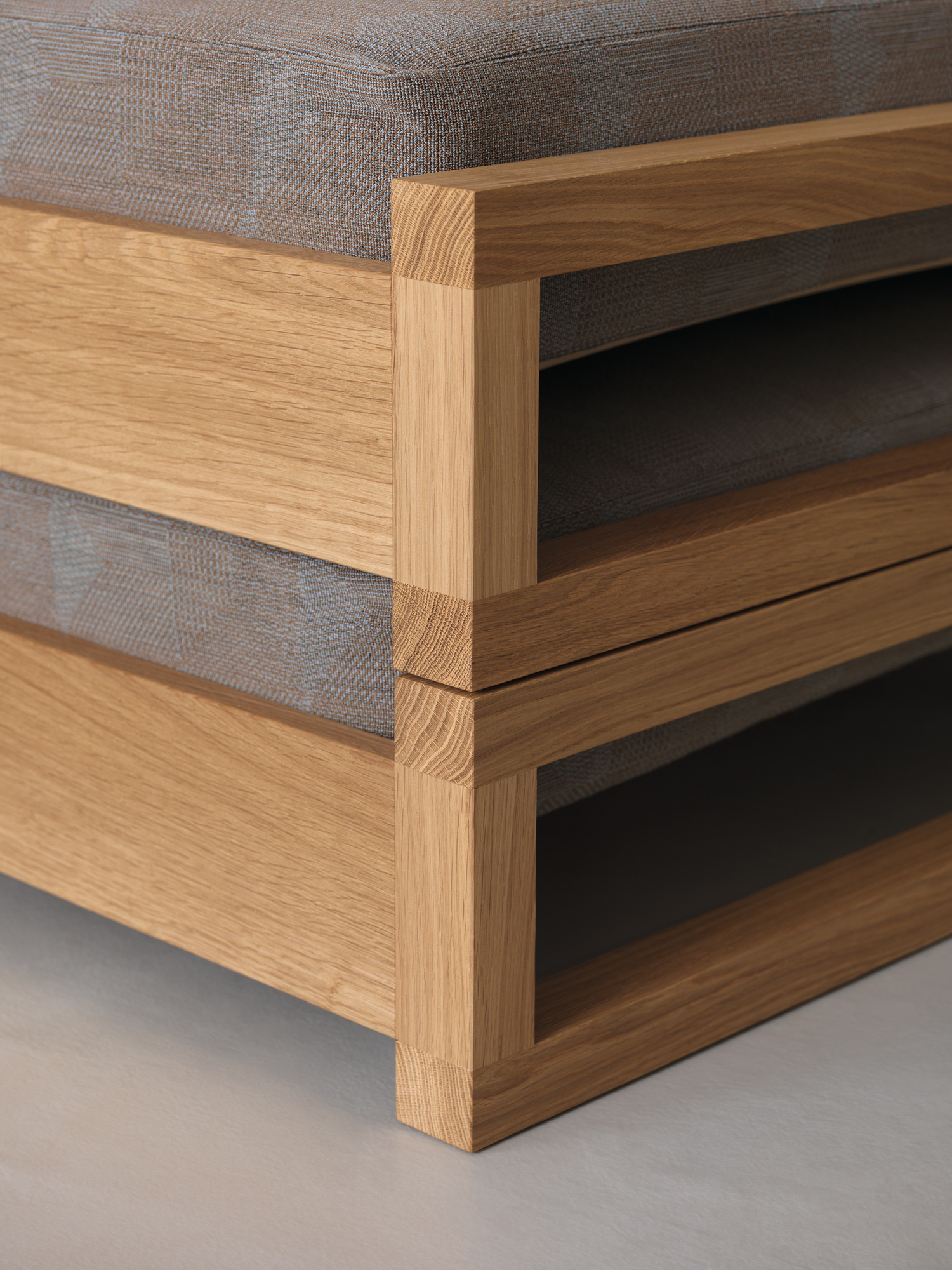 Detailaufnahme: Guest 90 Holzbett Eiche, Massivholzrahmen mit Stoffbezug, modernes Design für Schlafzimmer.