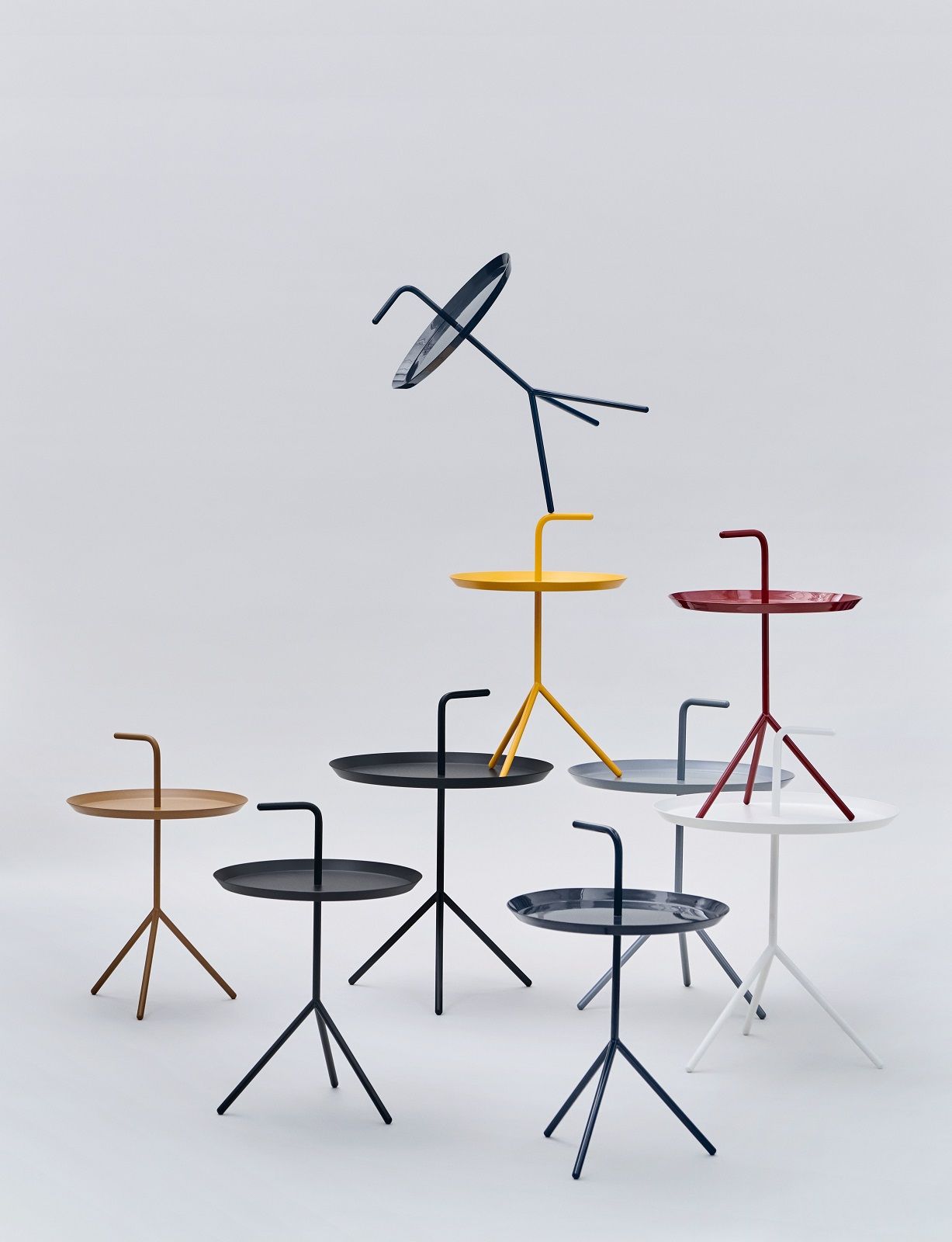 Mehrere farbige Hay DLM Beistelltische mit Griff auf weißem Hintergrund, modernes Design.