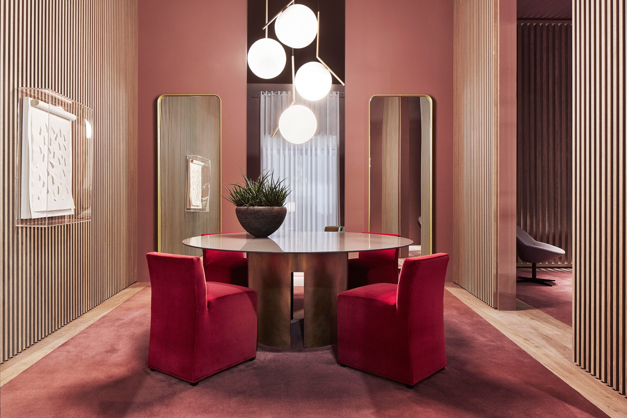 IC Lights Pendelleuchte von Flos über Esstisch mit roten Stühlen in stilvollem Interieur.