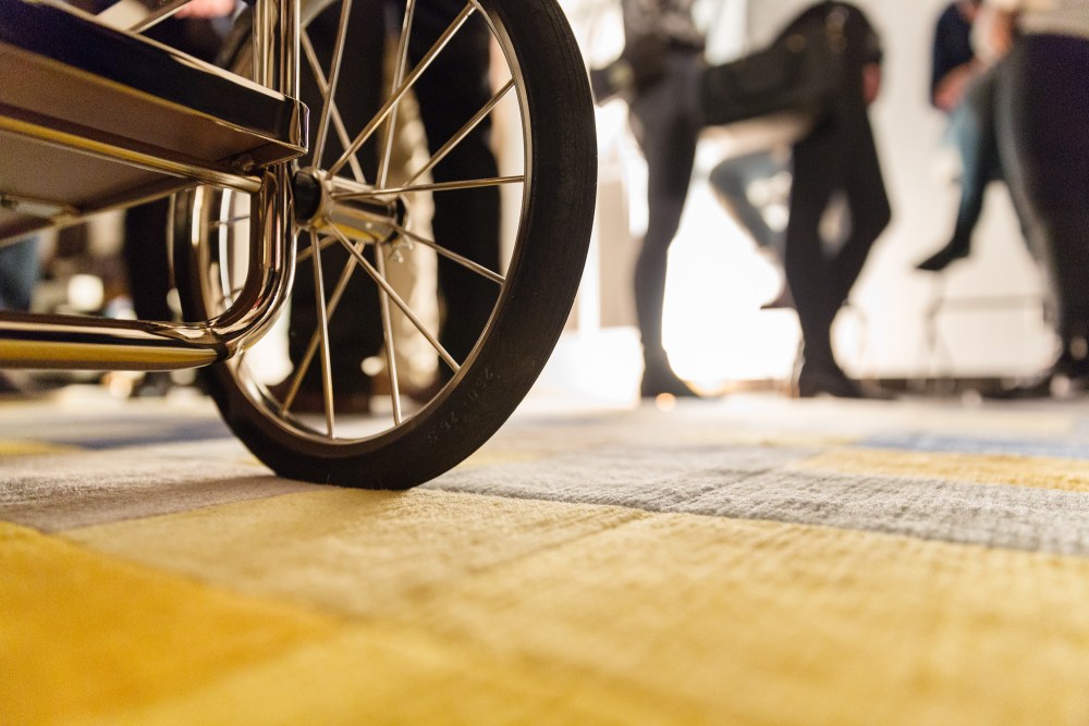 Detailaufnahme: Rad des Tecta M4RS Barwagens in Nussbaum und Silbergrau. Mobiler Servierwagen für stilvolle Einrichtung.