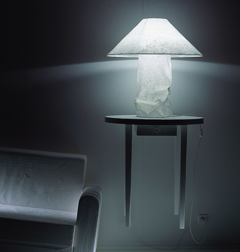 Lampampe Tischleuchte von Ingo Maurer: Papierleuchte auf kleinem Tisch, stimmungsvolles Licht.