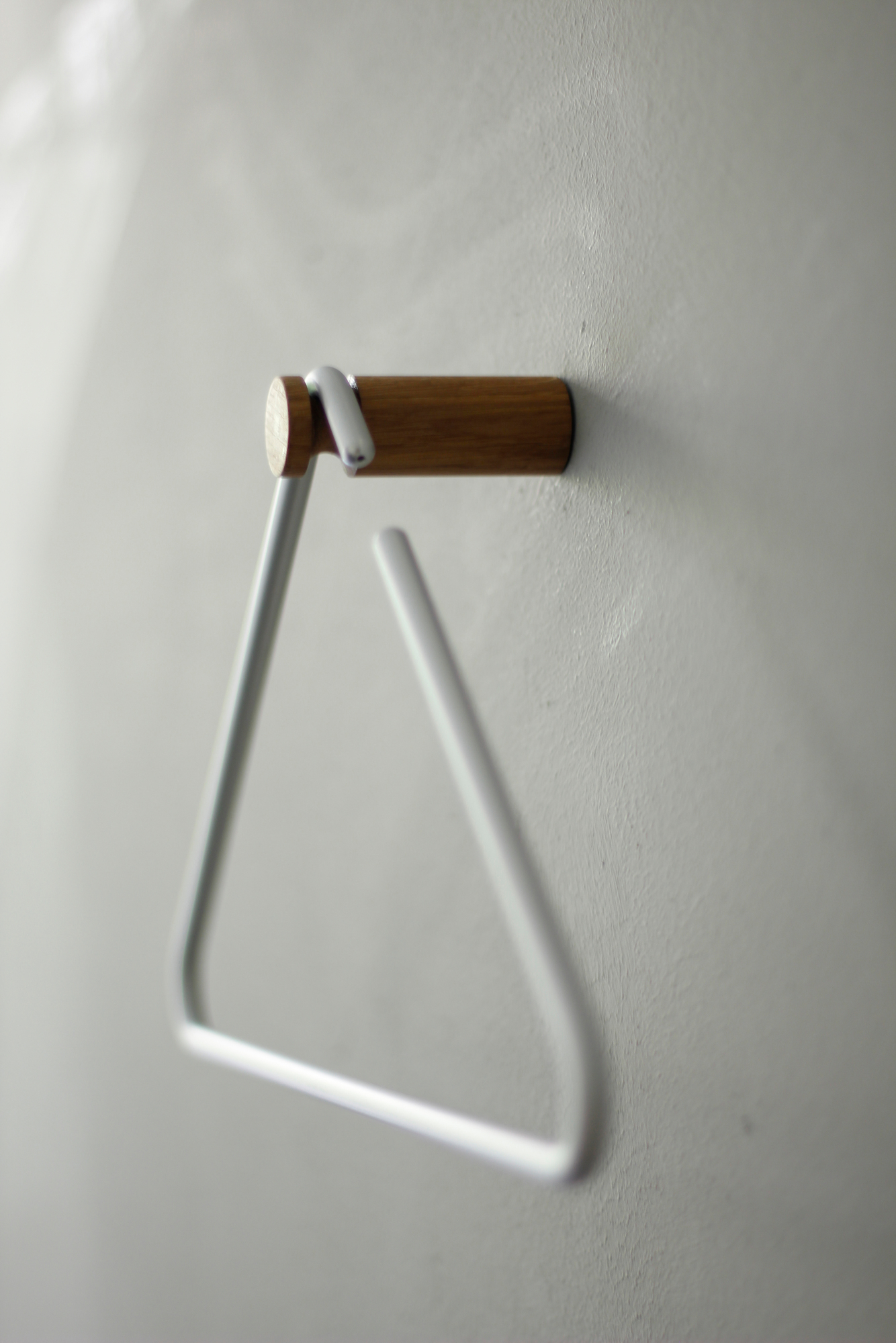 Roomsafari Triangle Kleiderbügel in Weiß an Wand montiert, minimalistisches Design für Garderobe und stilvolle Aufbewahrung.