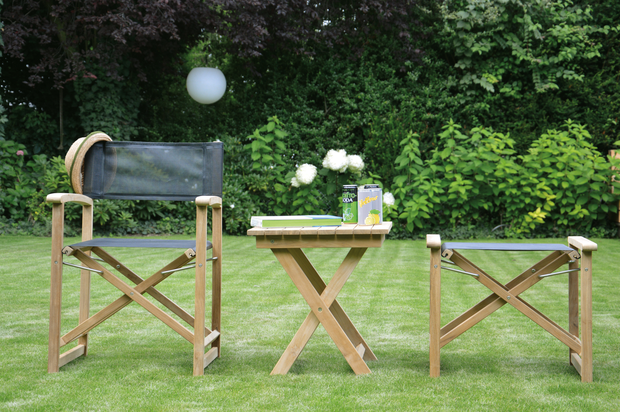 Urban Regiesessel von Jan Kurtz mit taupefarbenem Bezug und passendem Beistelltisch im Garten.
