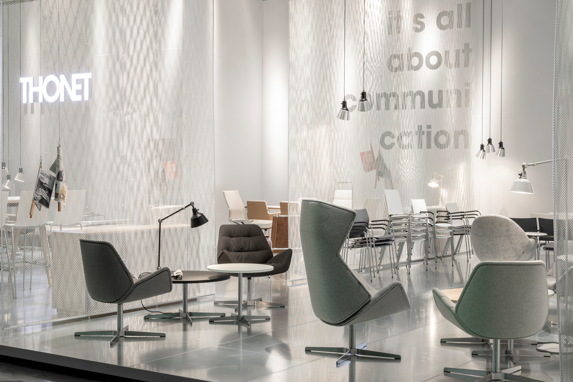 Ausstellungsraum mit Thonet Möbeln, inklusive 1808 Beistelltisch und Sesseln in Grau und Weiß.