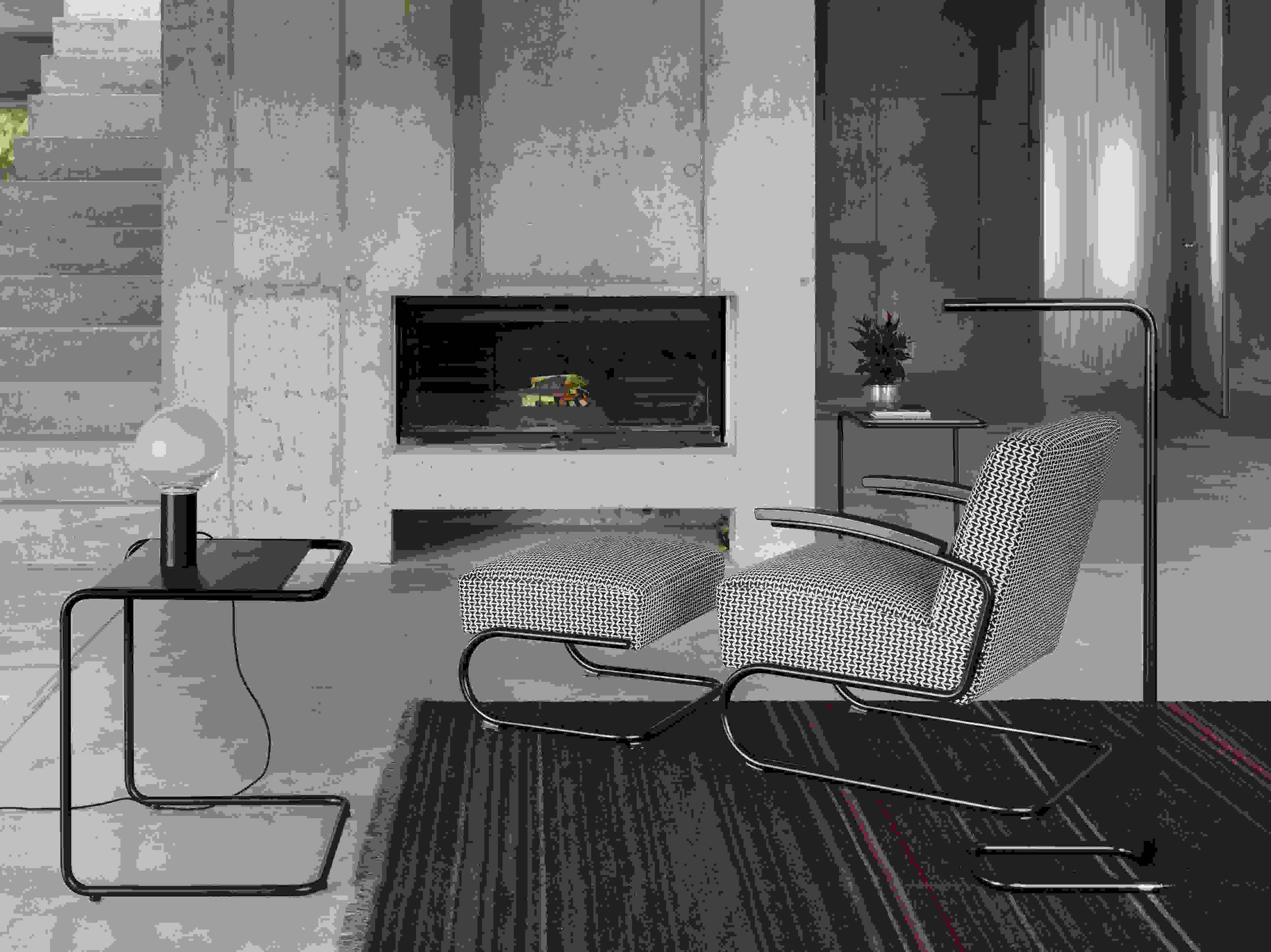 Lum LED Stehleuchte von Thonet, verchromt, im modernen Wohnzimmer mit Sessel und Kamin.