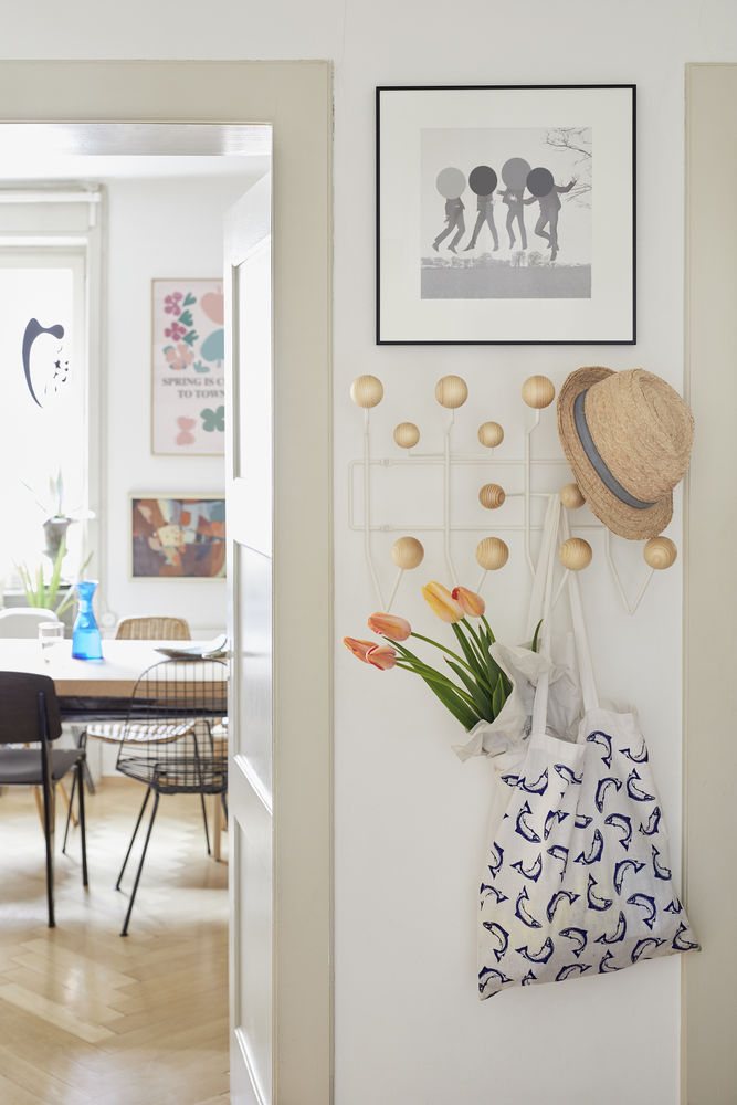 Flur-Szene mit Garderobe, Hut, Tulpen in Tragetasche und Blick ins Esszimmer. Dekorative Wandgestaltung.