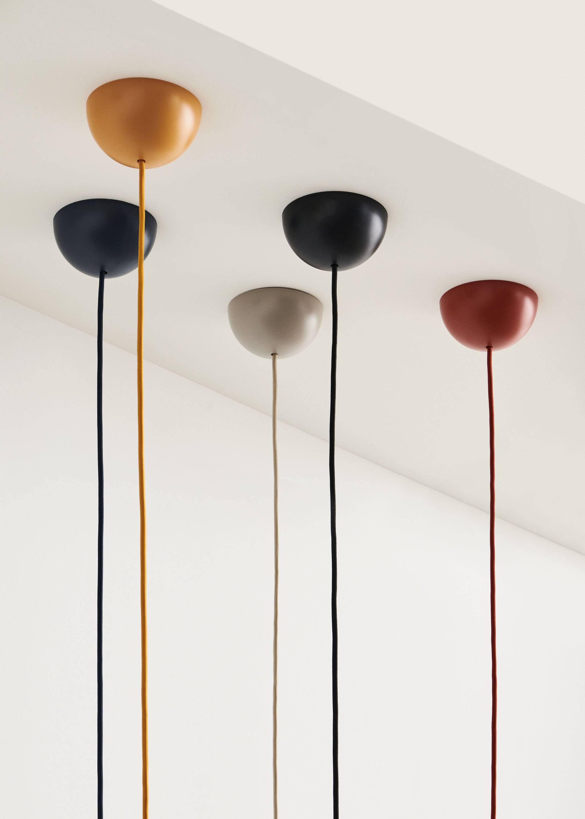 Mehrere Common Cord Sets für Pendelleuchten in verschiedenen Farben an einer Decke.