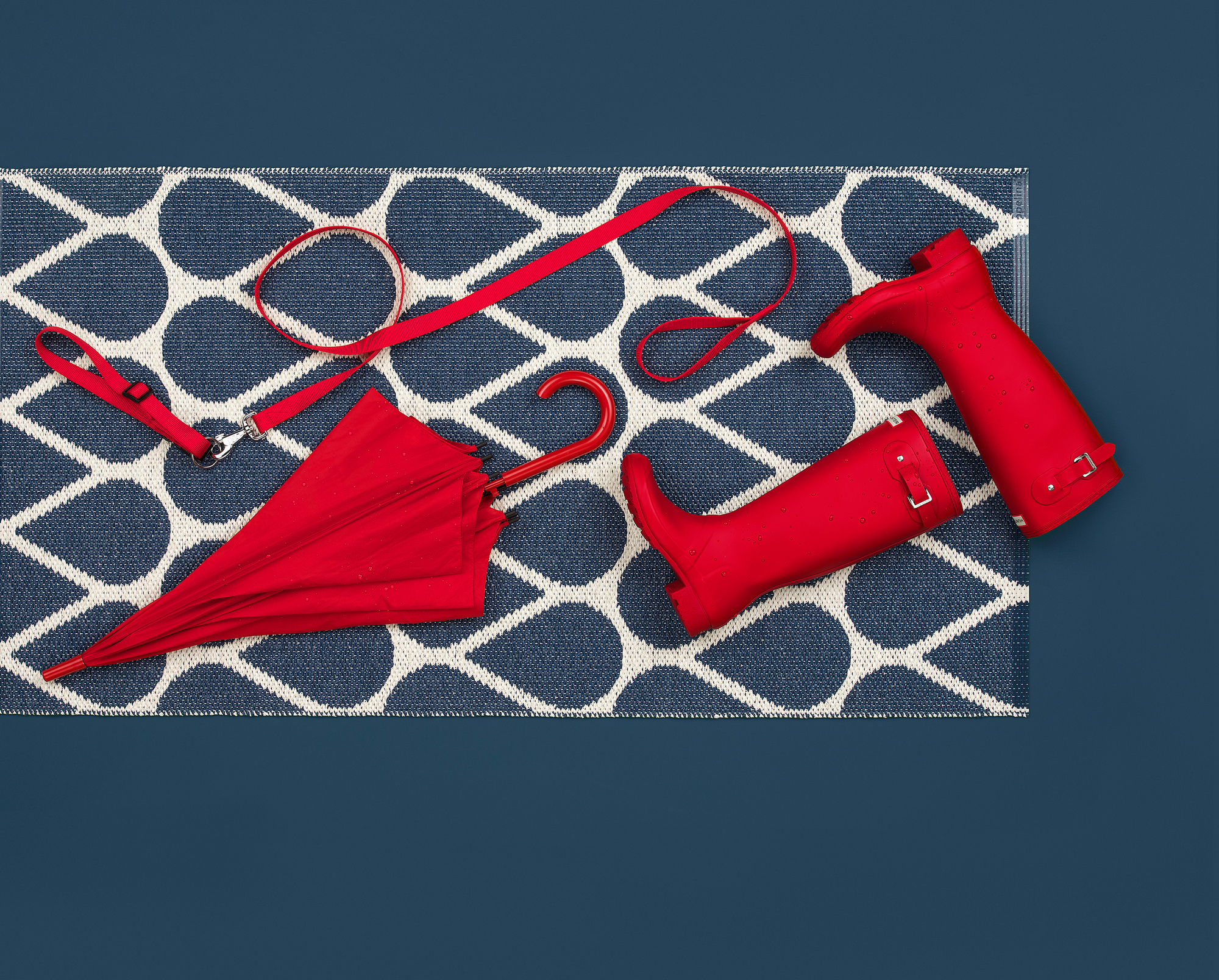 Otis Kunststoffteppich von Pappelina, 70x140 cm, blau-weiß mit Regenschirm, Leine und Gummistiefel.