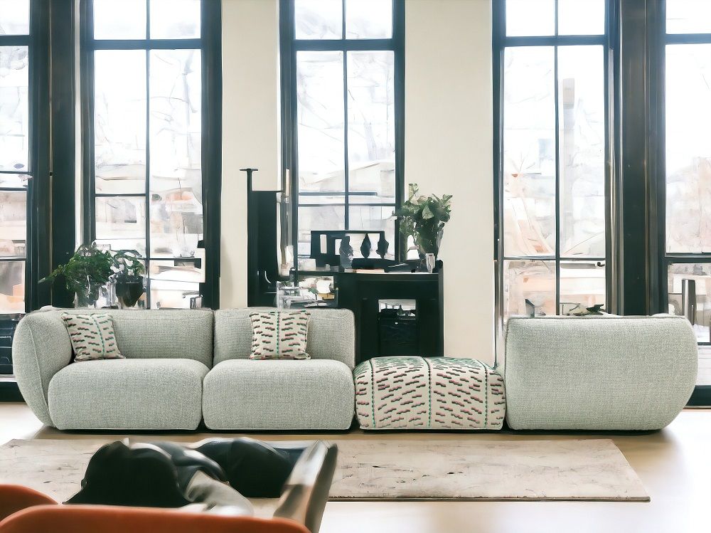 Helles Wohnzimmer mit modularem Sofa in Grau, passendem Hocker und dekorativen Kissen. Moderne Wohnzimmereinrichtung.