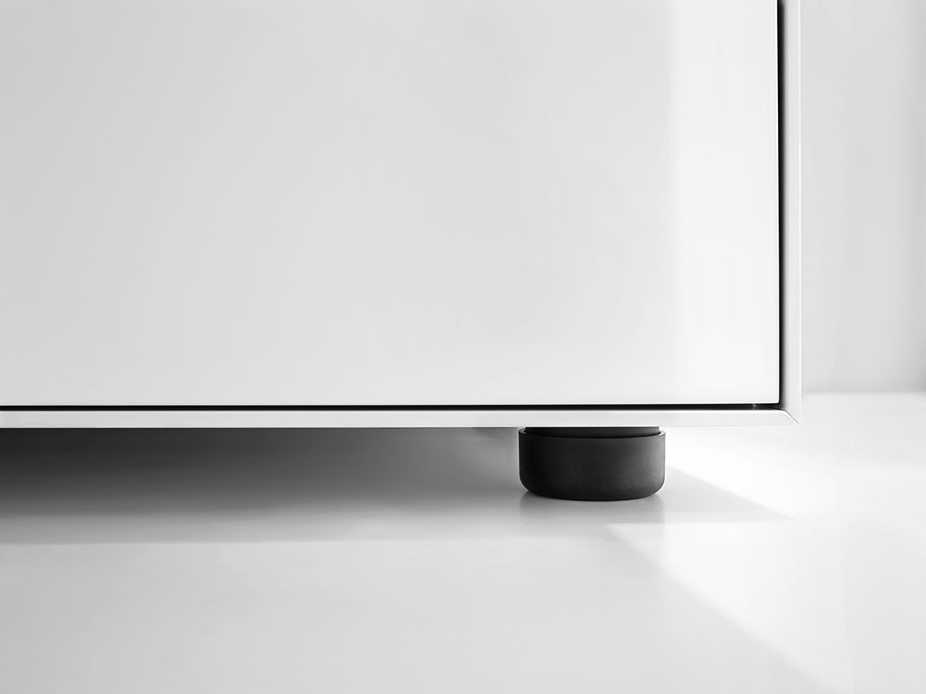 Detailaufnahme: Weißes Nex Pur Box TV-Lowboard von Piure mit schwarzem Fuß.