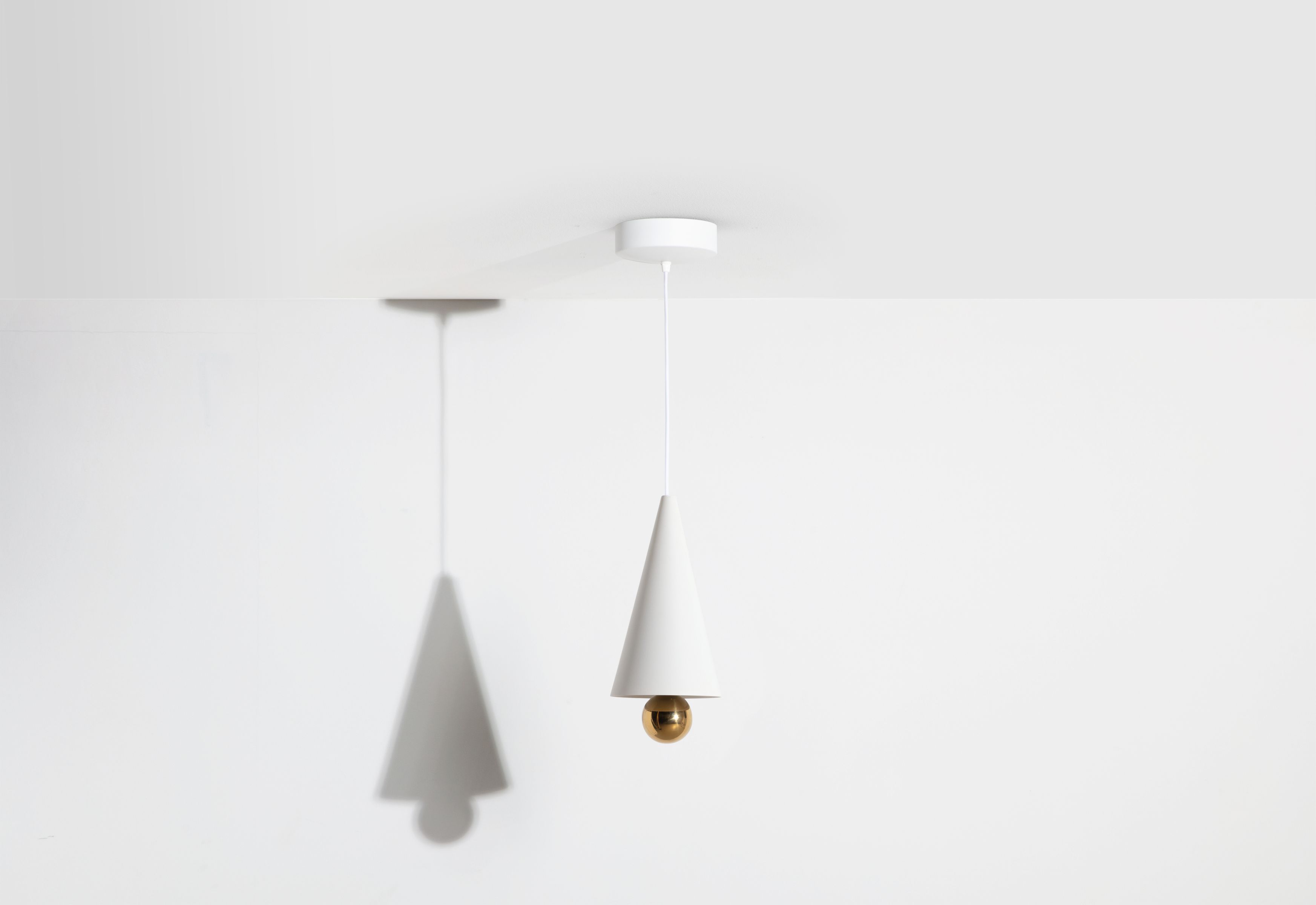 Weiße Cherry Pendelleuchte von Petite Friture mit Kegelform und goldener Kugel.