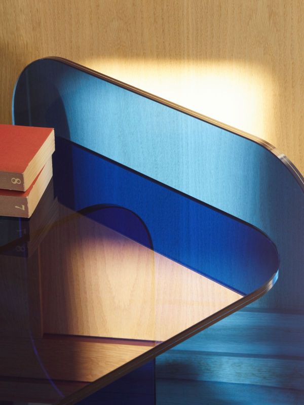 Detailaufnahme des ClassiCon Sol Beistelltisches aus royalblauem Kristallglas mit Büchern. Designermöbel für Wohnzimmer.