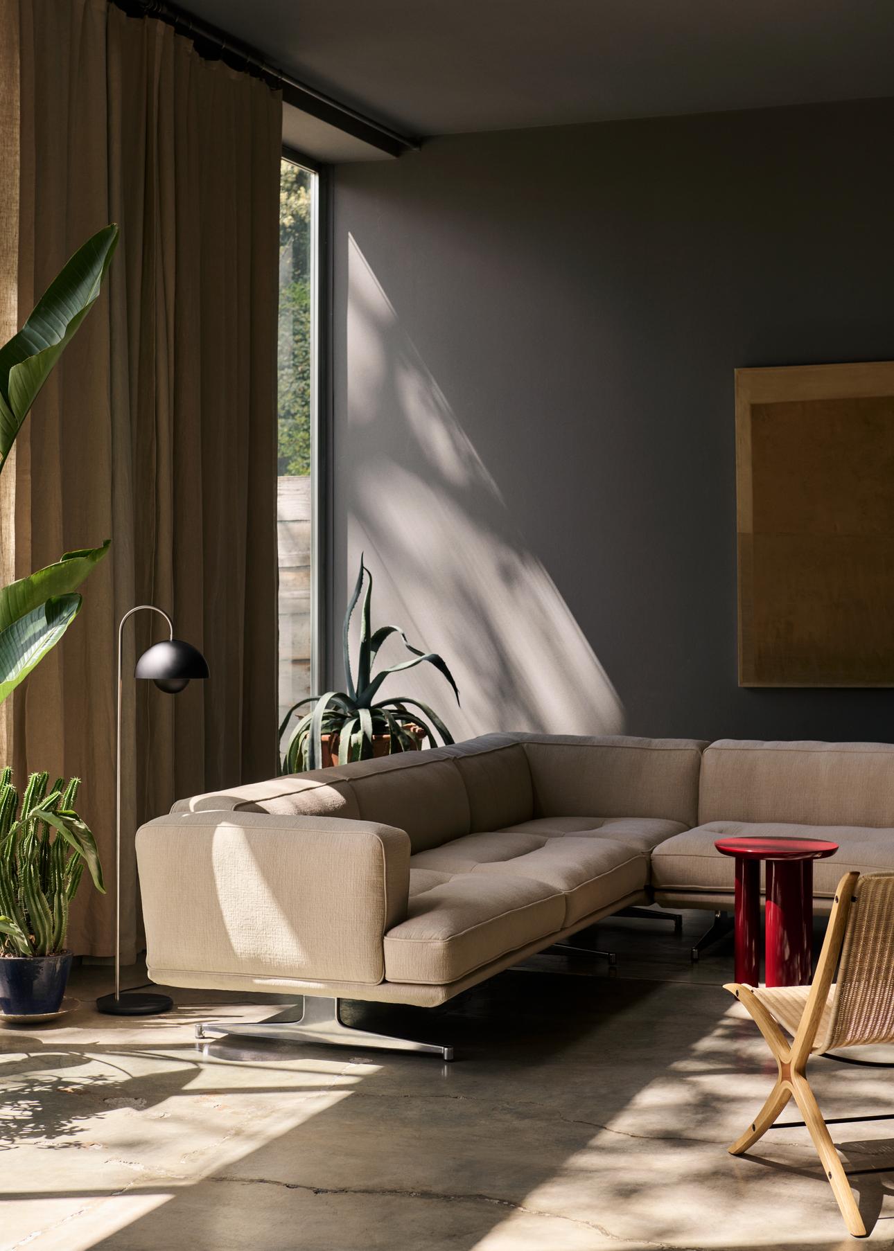 Wohnzimmer mit Flowerpot VP12 Stehleuchte von AndTradition in Schwarz matt neben beigem Sofa.