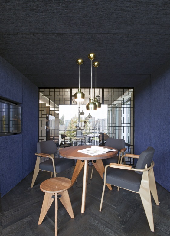 Vitra Guéridon Tisch Ø 90 cm aus Holz mit Stühlen in modernem Büro.