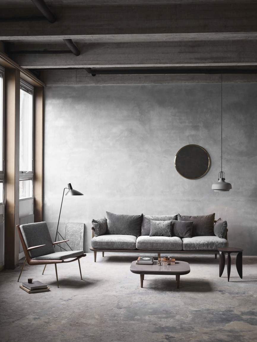 Grauer AndTradition Fly Table Couchtisch im modernen Wohnzimmer mit Sofa und Sessel.