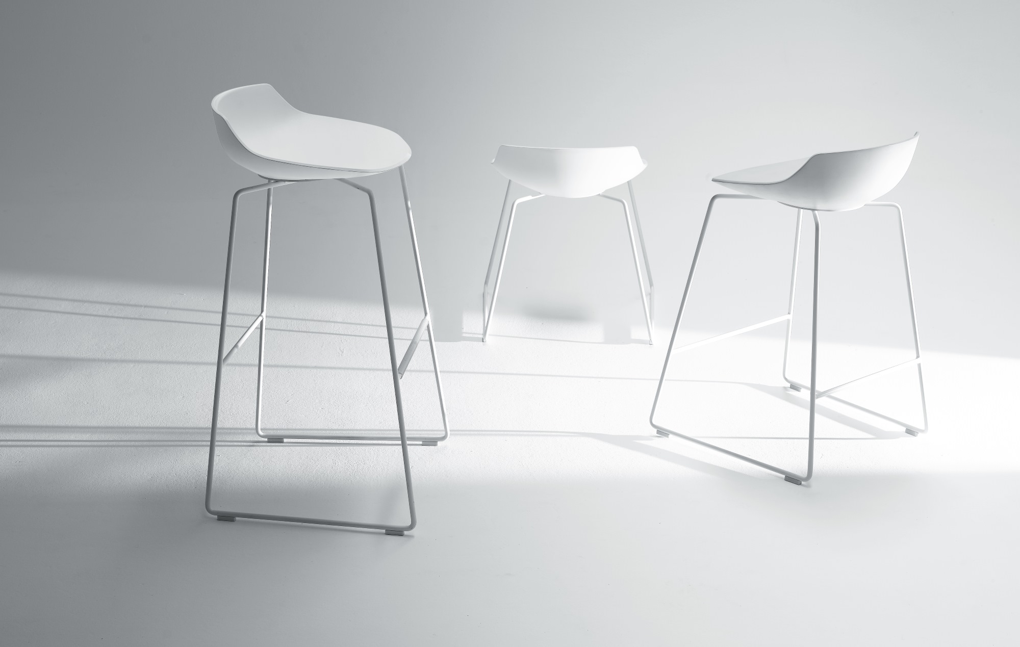 Drei weiße Flow Stool Hocker von MDF Italia mit minimalistischem Design und Stahlgestell.