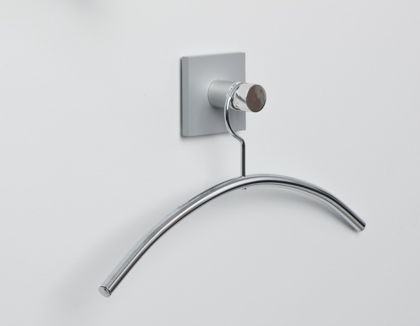 Hangon 1 Kleiderhaken aus poliertem Aluminium mit Kleiderbügel an einer weißen Wand.