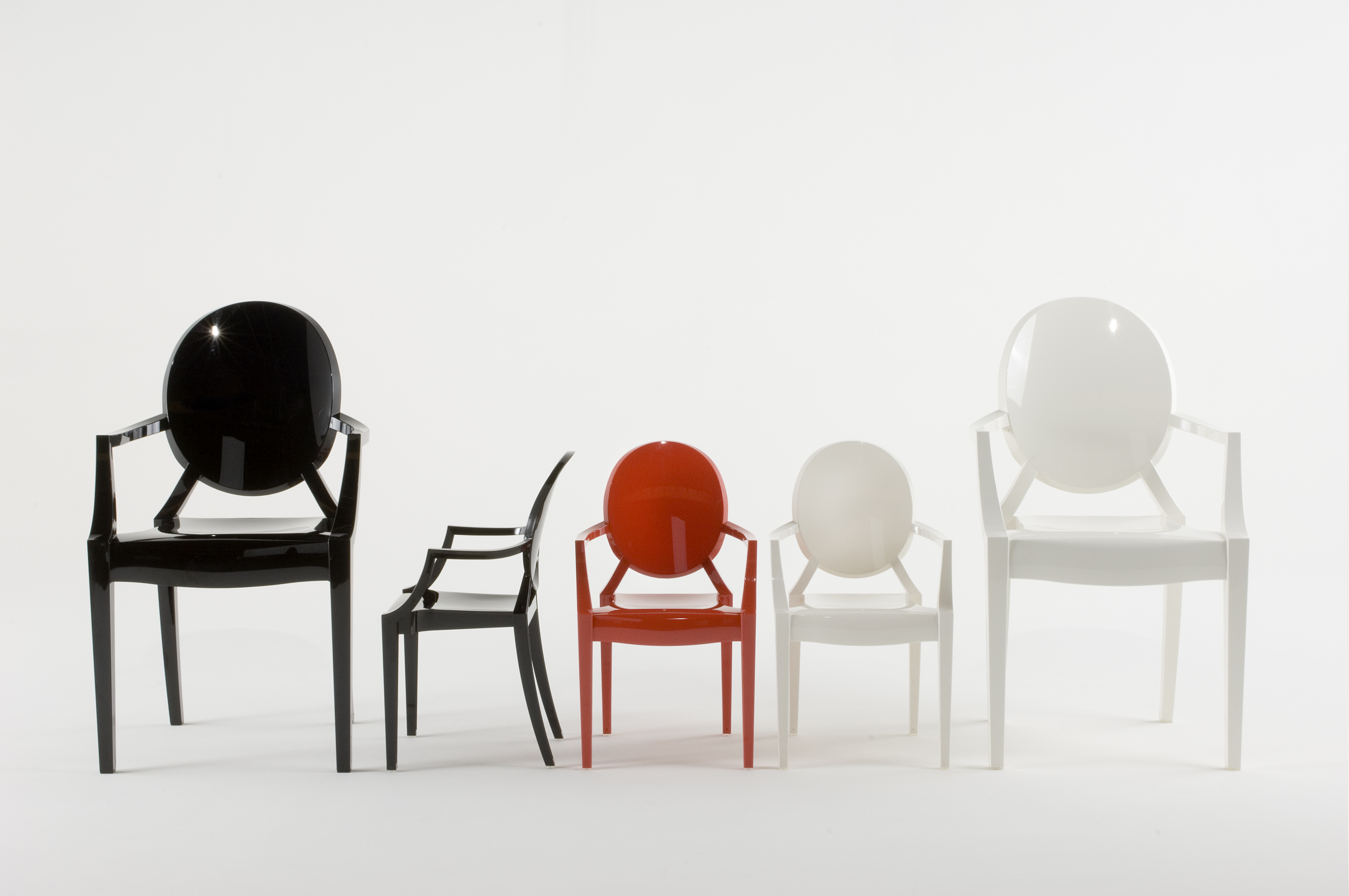 Fünf Lou Lou Ghost Kinderstühle von Kartell in Schwarz, Rot und Weiß auf weißem Hintergrund.