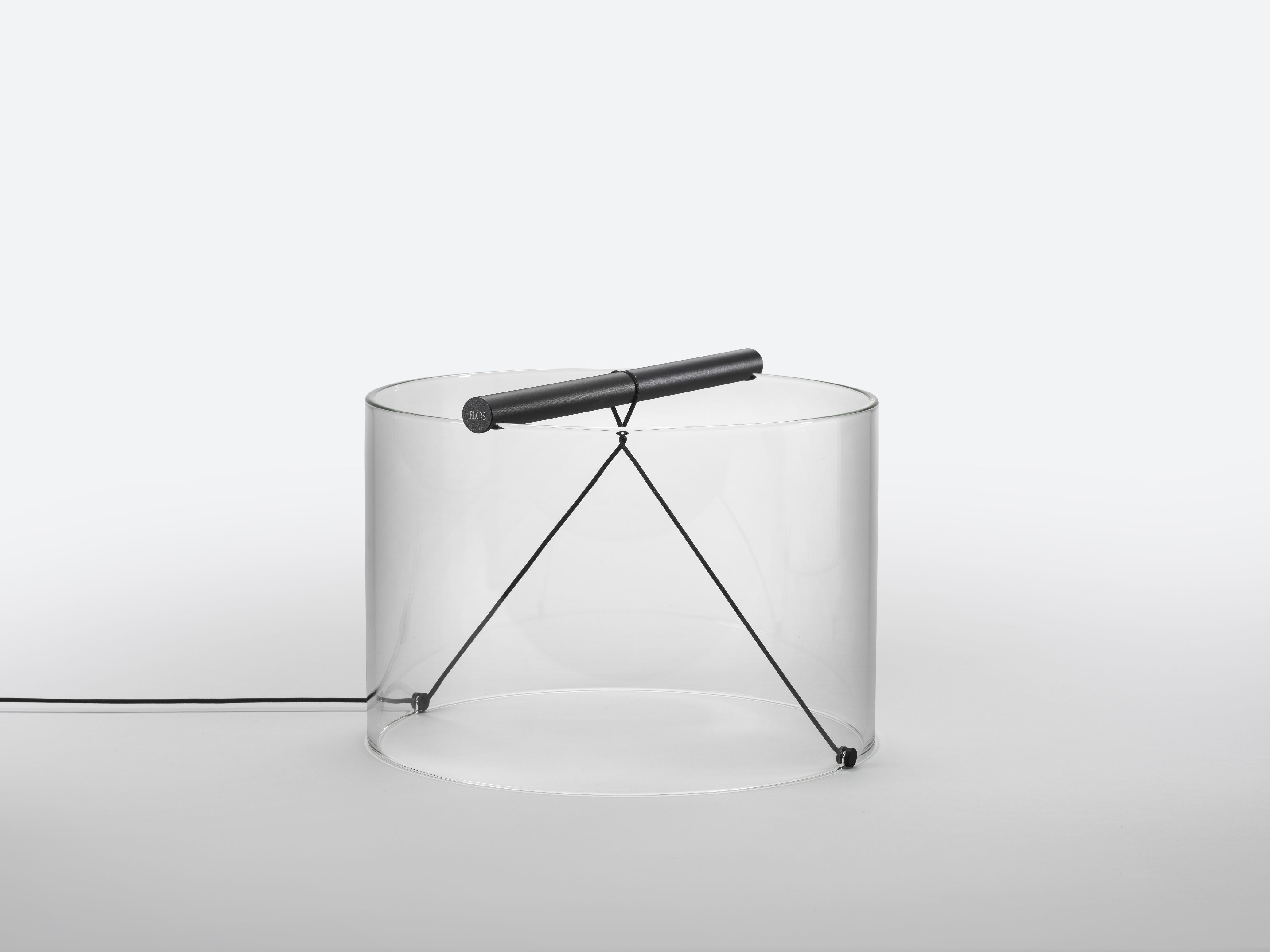 To-Tie T3 LED Tischleuchte von Flos, schwarz eloxiert, mit transparentem Zylinder und schwarzem Kabel.