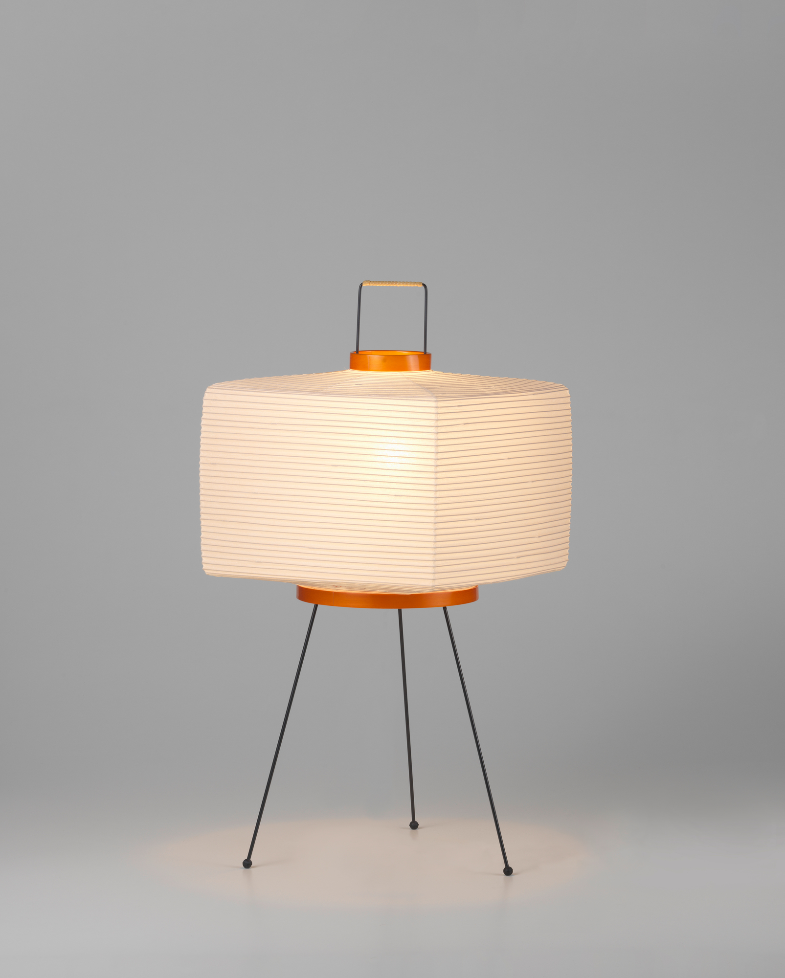 Akari Tischleuchte 7A von Vitra: Japanische Papierleuchte mit schwarzem Drahtgestell und warmem Licht.