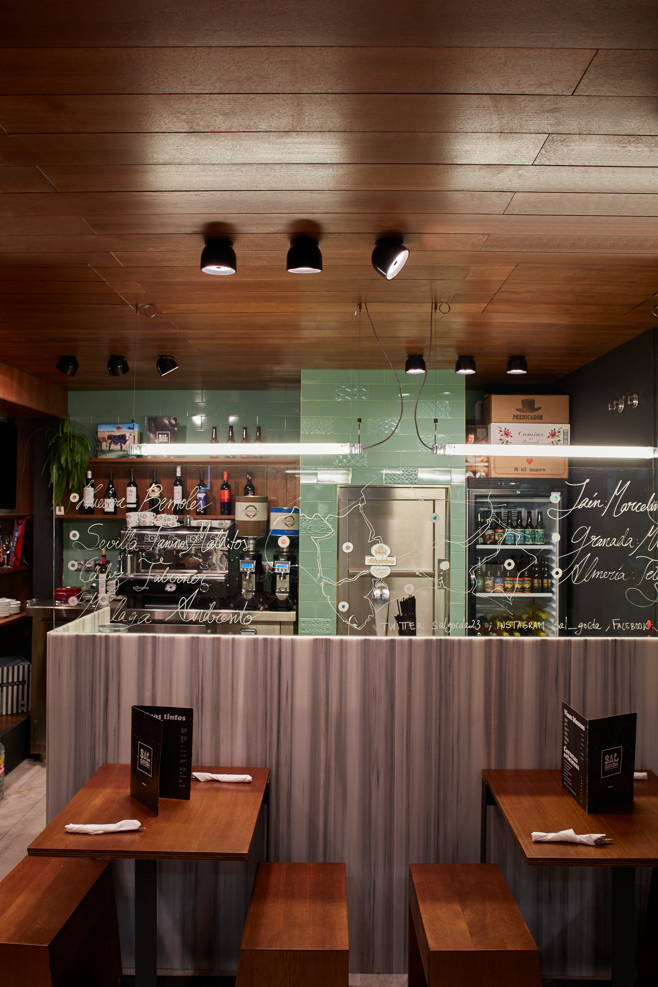 Nahaufnahme von mehreren schwarzen Wan C/W Deckenleuchten von Flos an einer Holzdecke in einem Restaurant.