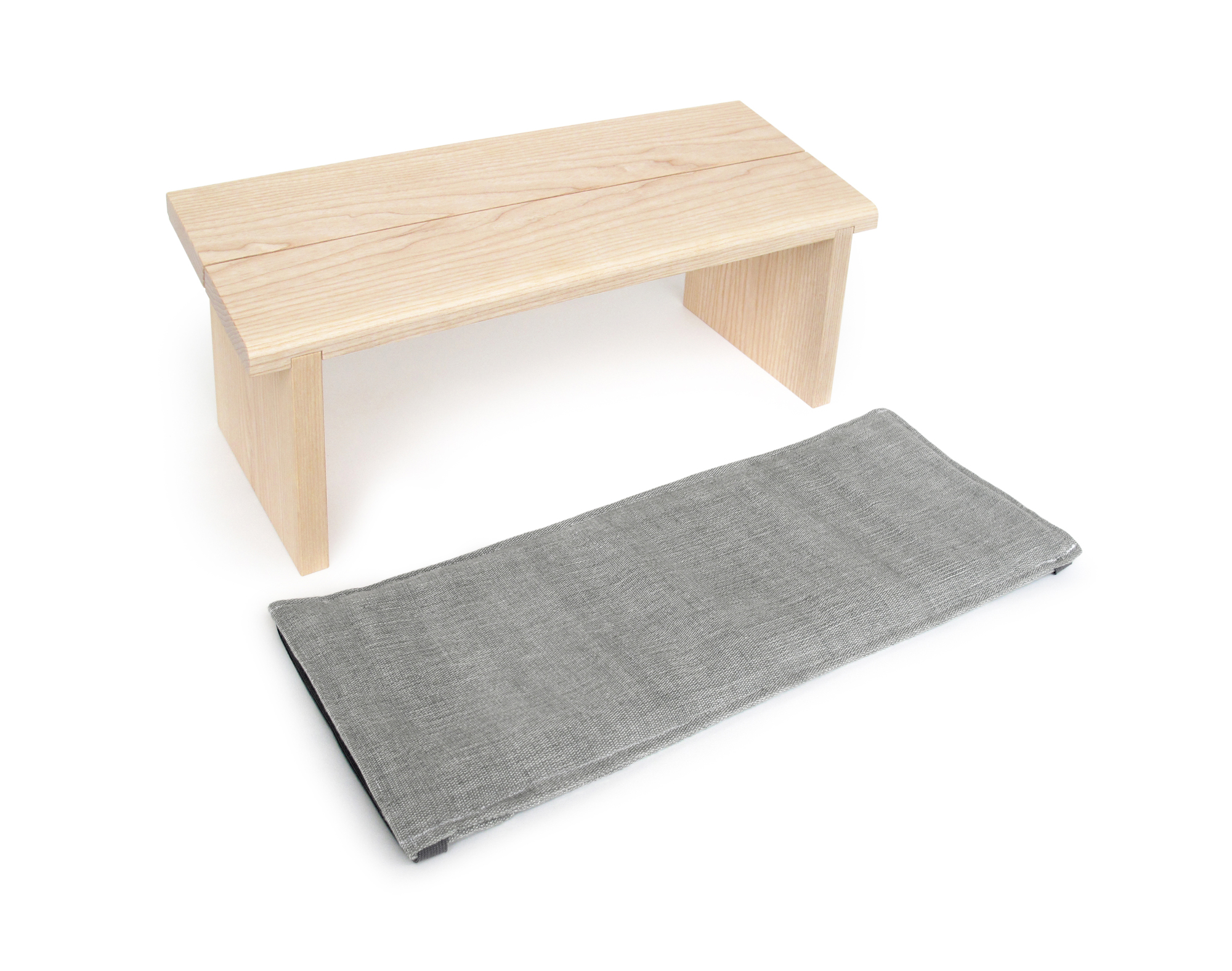 Meditationsbank aus Holz mit grauem Meditationskissen für bequemes, entspanntes Sitzen bei der Meditation.