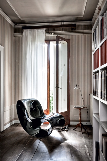 Schwarzer VOIDO Schaukelstuhl von Magis in einem stilvollen Wohnzimmer mit Holzboden und Bücherregal.