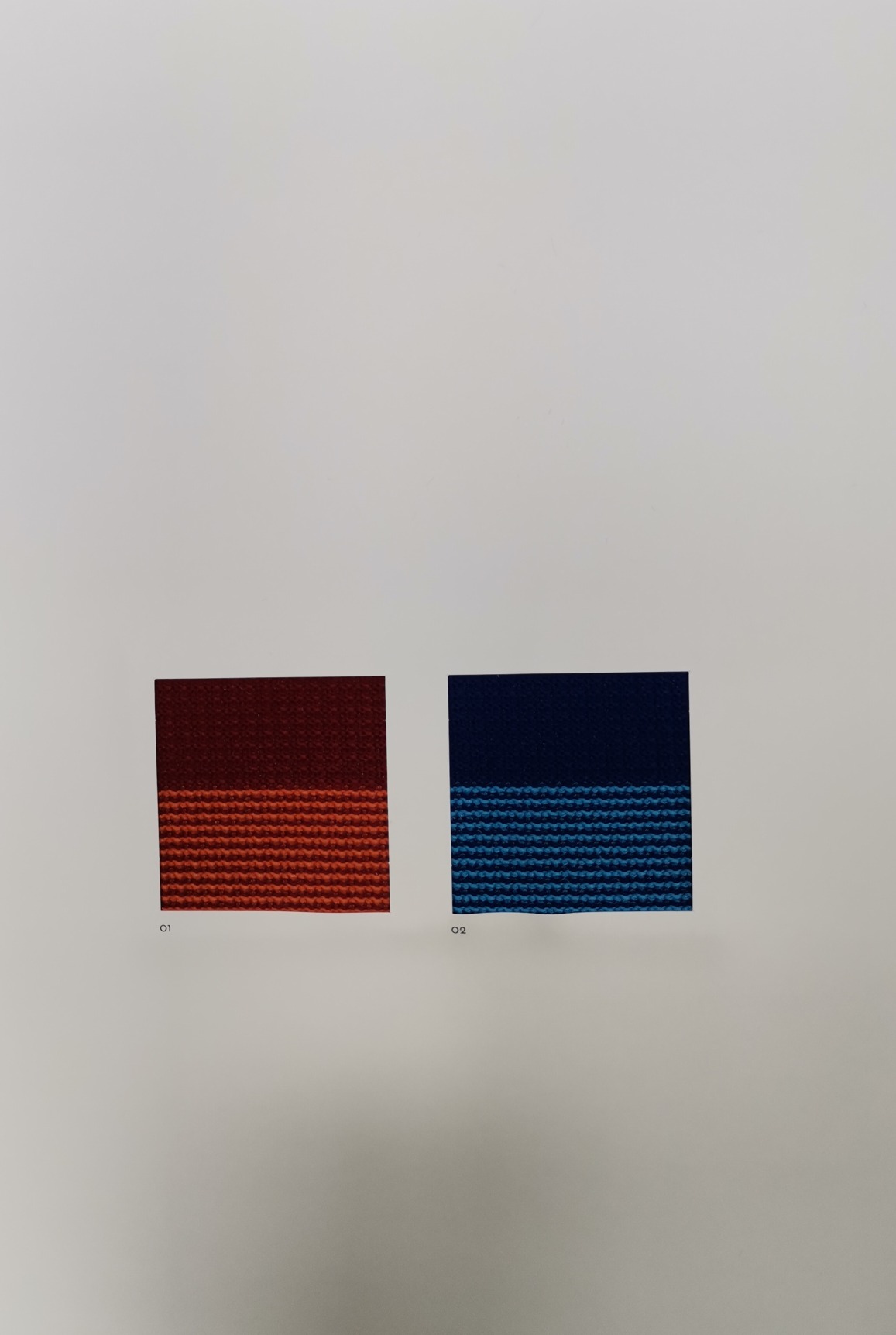 Stoffmusterkarte Vitra Duo Knit/Striped Knit: Zwei Stoffmuster in Rot-Orange und Blau.