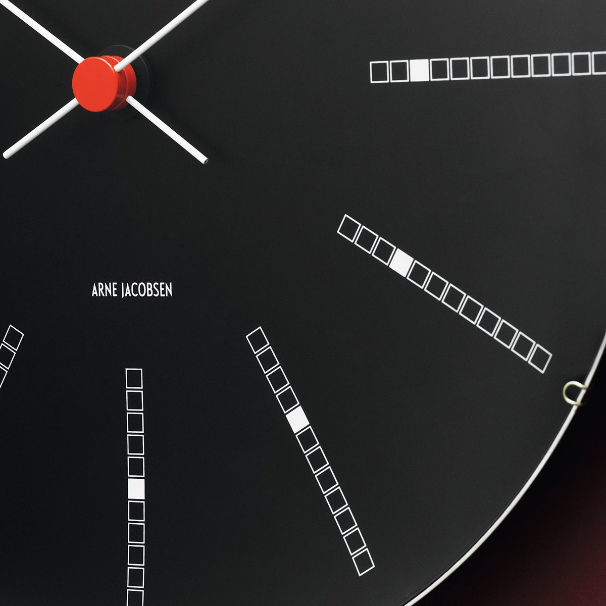 Schwarze Bankers Wanduhr von Rosendahl Timepieces mit weißem Zifferblatt und roten Zeigern.