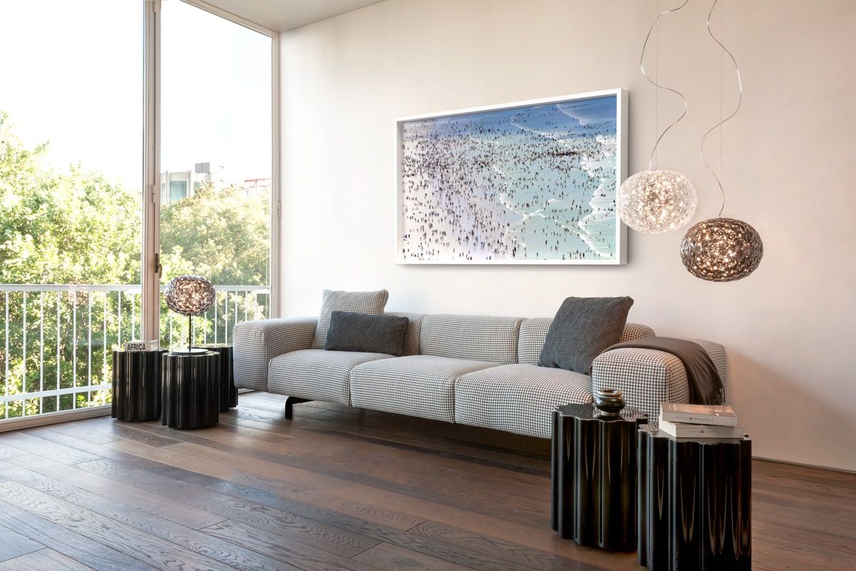 Planet Tischleuchte von Kartell, 53 cm, in Bernstein, auf einem schwarzen Beistelltisch im Wohnzimmer.