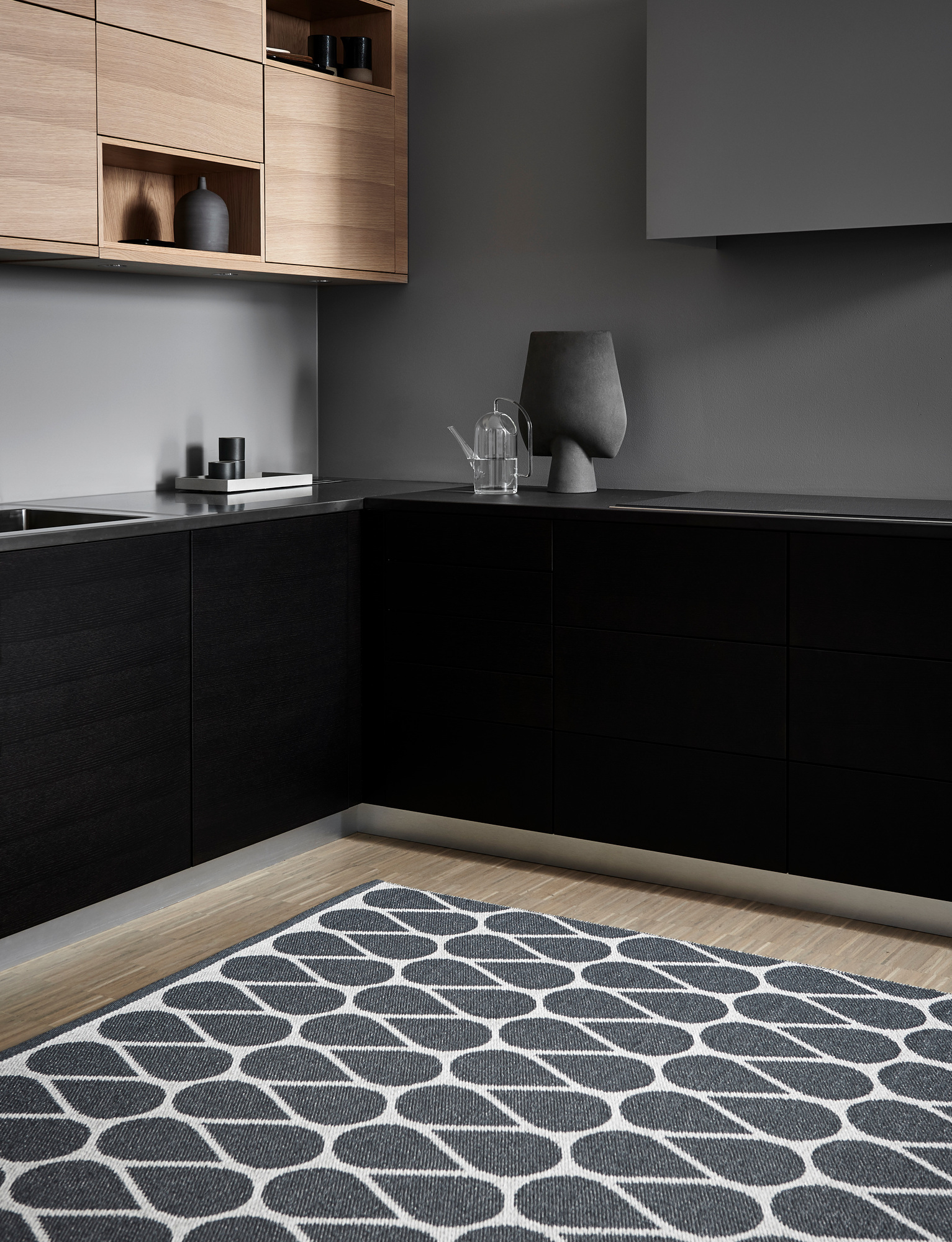 Otis Kunststoffteppich von Pappelina, 70x200 cm, in einer modernen Küche mit grafischem Muster.