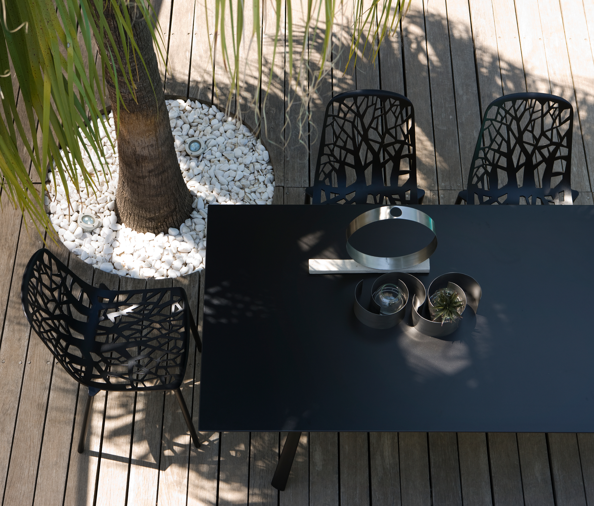 Draufsicht: Schwarze Forest Outdoor Stühle mit Baumdesign auf Holzterrasse, Gartenmöbel für den Außenbereich.