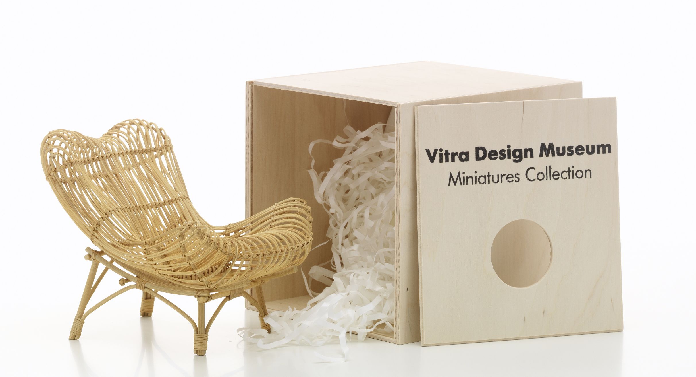 Geflochtener Miniatur Sessel "Gala" von Vitra neben einer Holzkiste der Miniatures Collection.