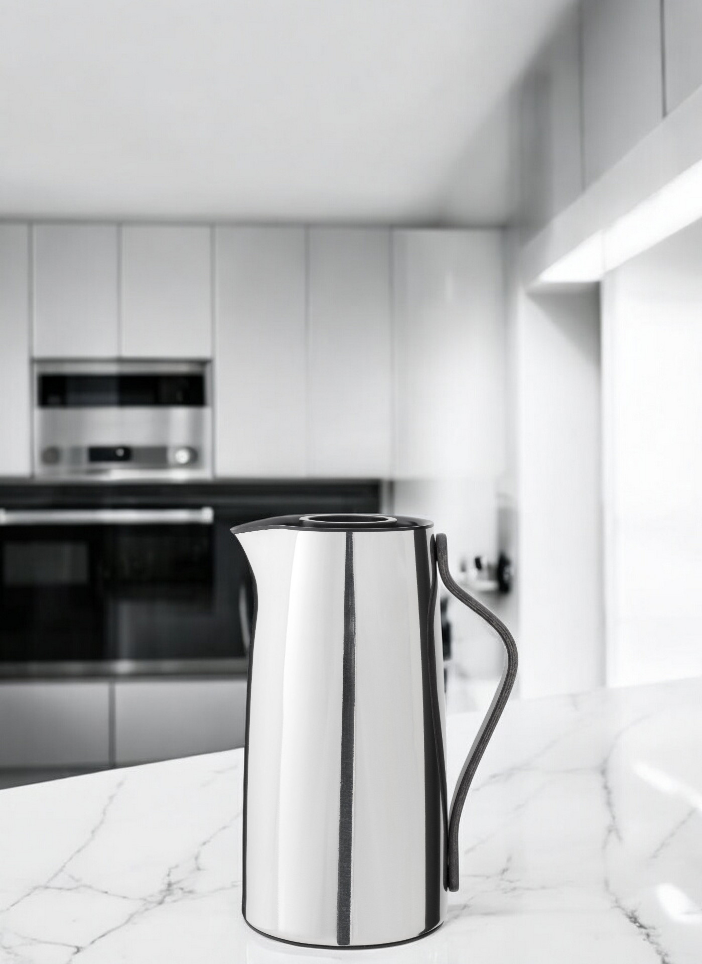 Emma Isolierkanne aus Edelstahl von Stelton auf einer Marmoroberfläche in einer modernen Küche.