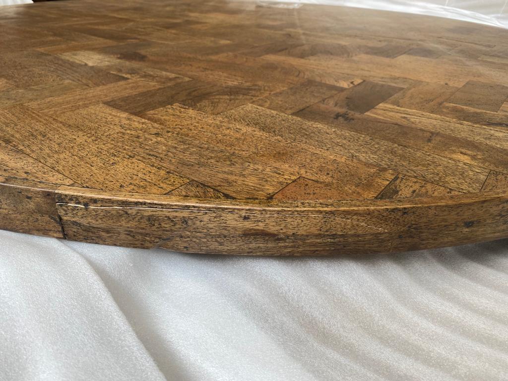 Detailaufnahme der Tischplatte des Kant Esstischs mit Holz-Fischgrätenmuster und erkennbarem Mangel.