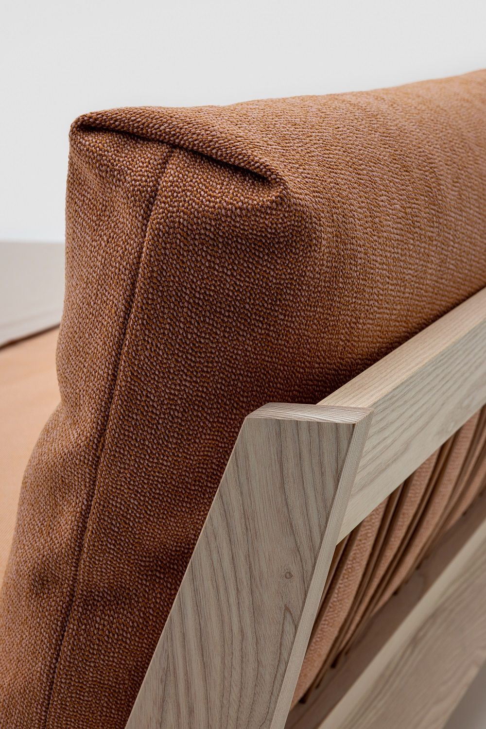 Detailaufnahme: Mellow Bett Massivholz, helles Holzgestell und braunes, strukturiertes Kopfteil. Hochwertiges Schlafzimmermöbel.