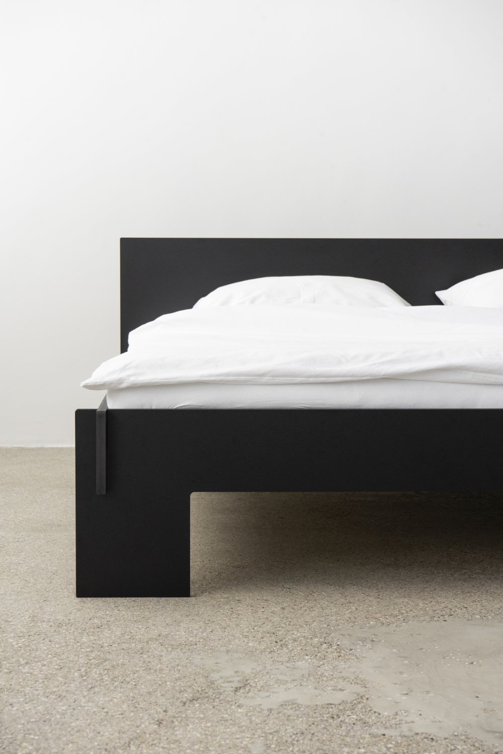 Schwarzes Siebenschläfer Bett mit Kopfteil von Moormann, Größe 160x200 cm, mit weißer Bettwäsche.