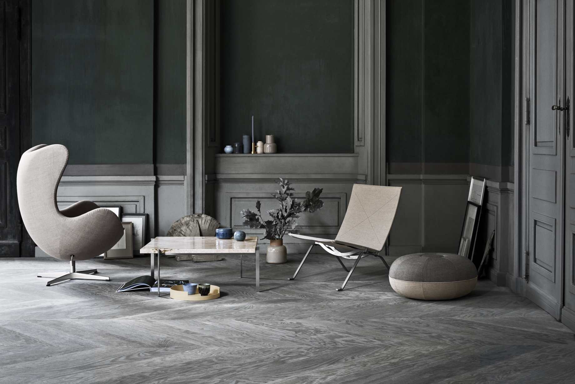 Wohnzimmer mit Designermöbeln: Fritz Hansen PK61 Couchtisch, Sessel und Stuhl in stilvollem Ambiente.