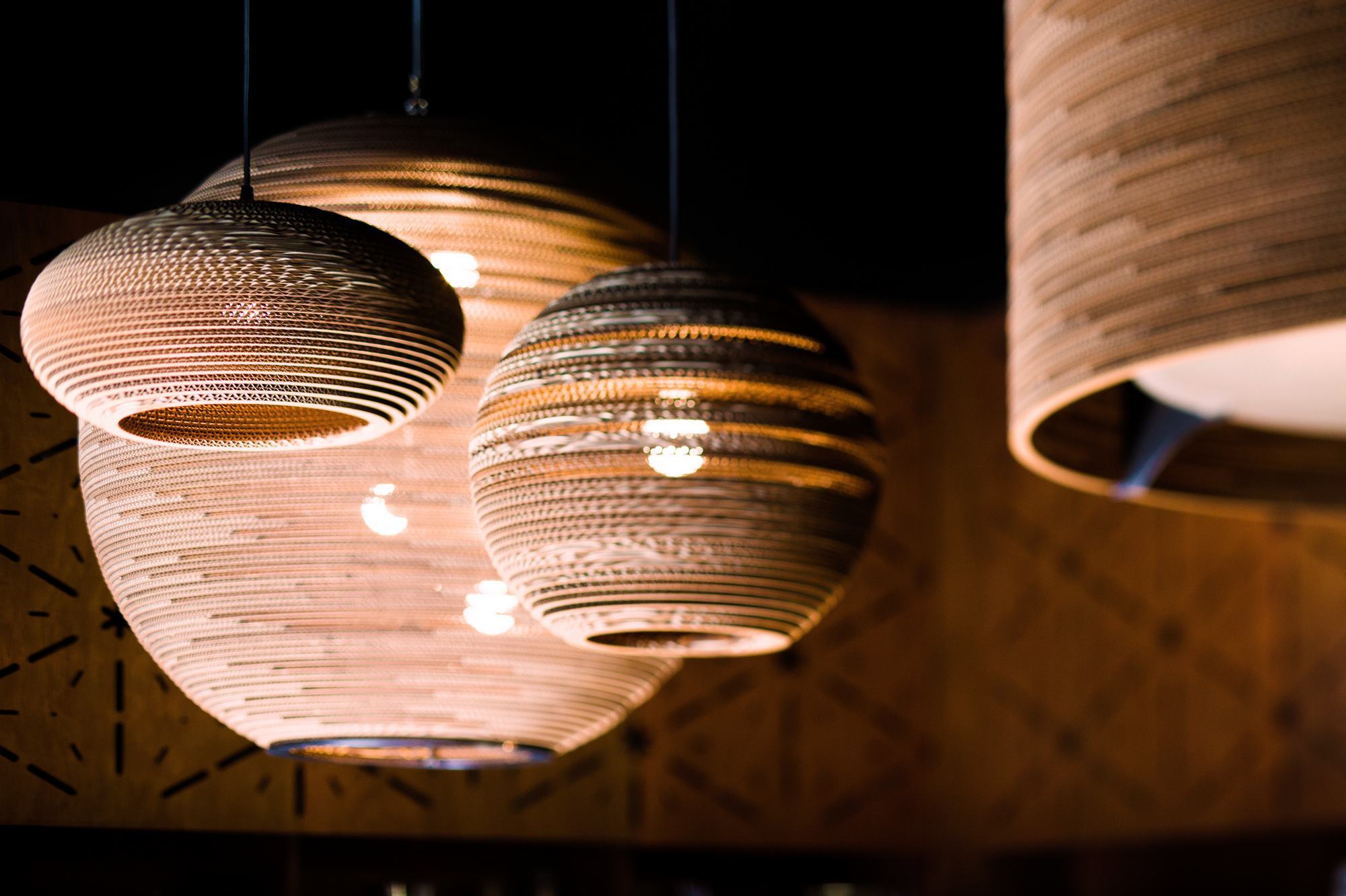 Mehrere Disc16 Scraplights Hängeleuchten von Graypants aus recycelter Pappe, warmes Licht.