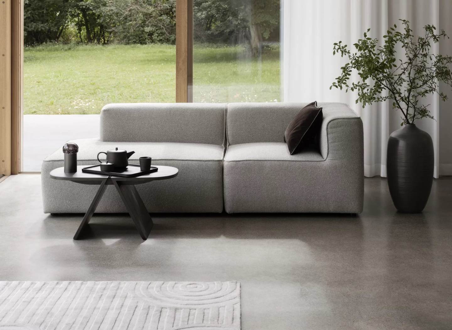 Blomus Uzu Rug Teppich im modernen Wohnzimmer mit Sofa, Tisch und minimalistischer Dekoration.