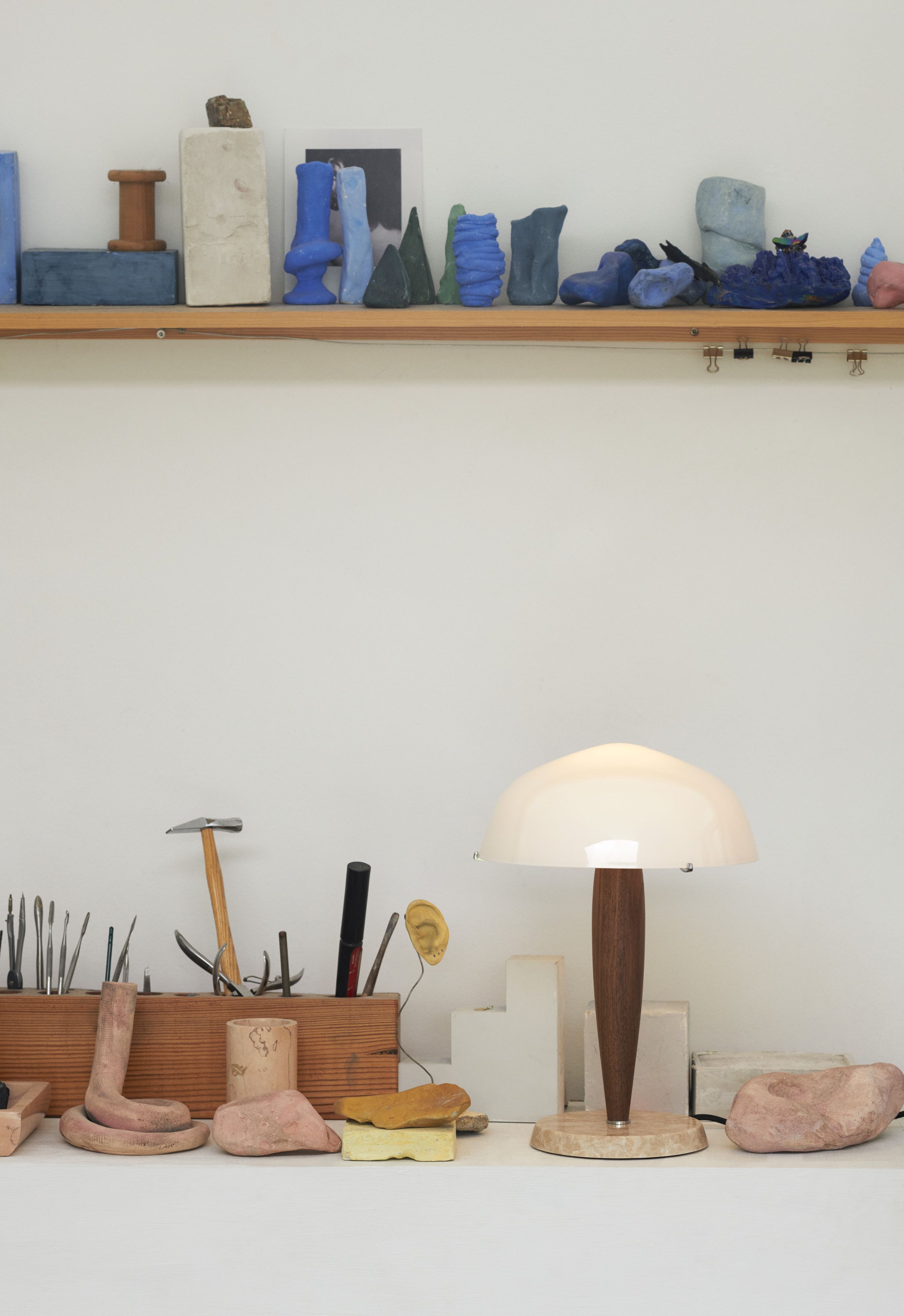 Helle Herman SHY3 Tischleuchte von AndTradition auf einem Tisch mit Werkzeugen und Skulpturen.